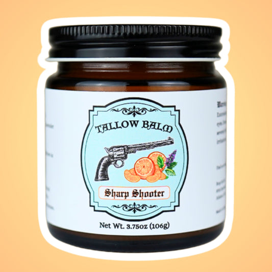 Sharp Shooter tallow balm in an amber glass jar, label shows a vintage revolver with orange slices and mint