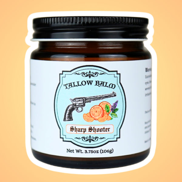 Sharp Shooter tallow balm in an amber glass jar, label shows a vintage revolver with orange slices and mint